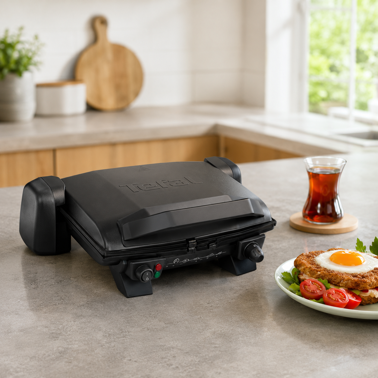 Gril électrique Tefal Toast Expert ouvert avec sandwichs gratinés sur table de petit-déjeuner