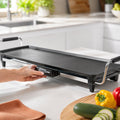 Plancha Taurus Maxi Giga Heat XL posée sur un plan de travail avec légumes et poivrons