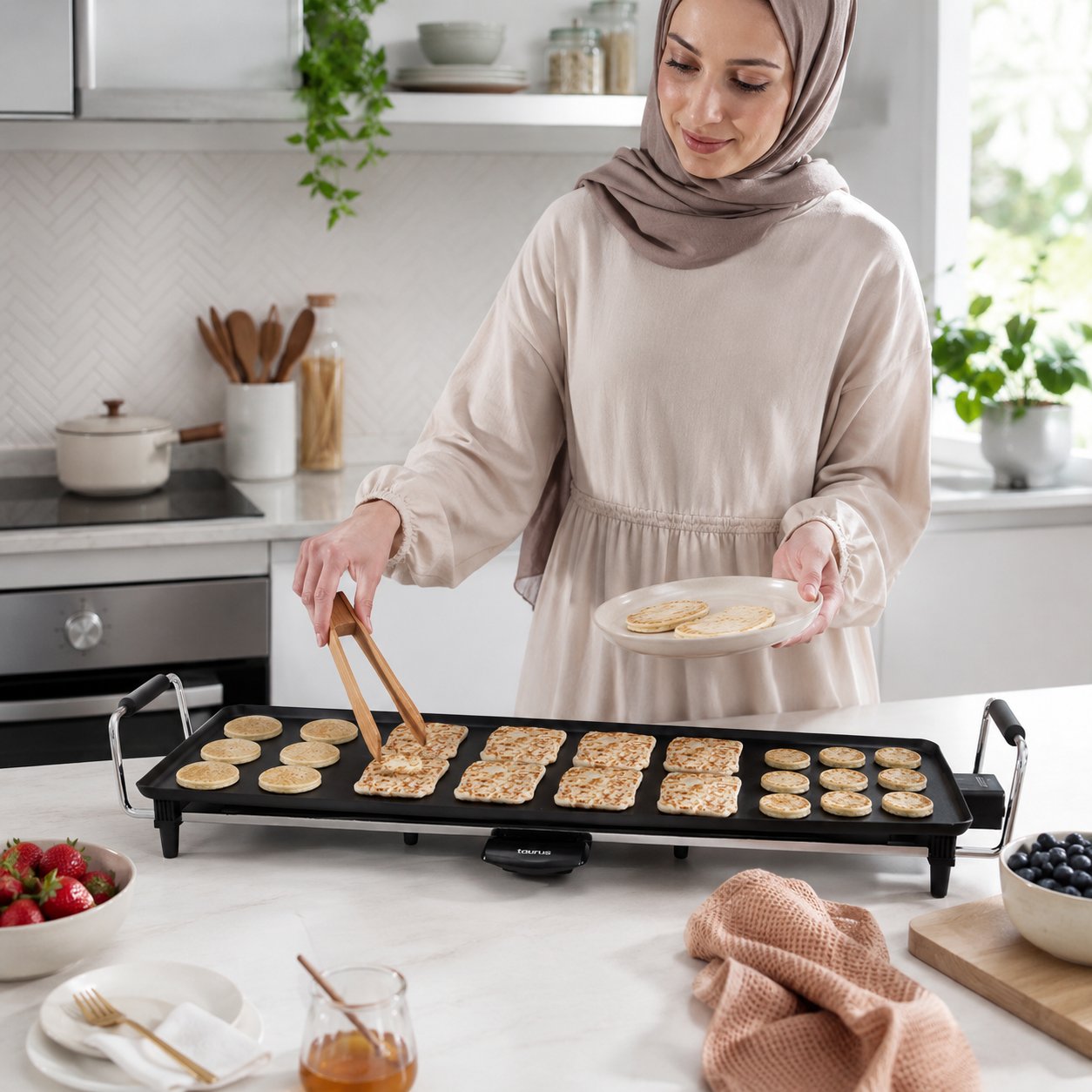 Femme en hijab préparant des pancakes sur la plancha Taurus dans une cuisine lumineuse