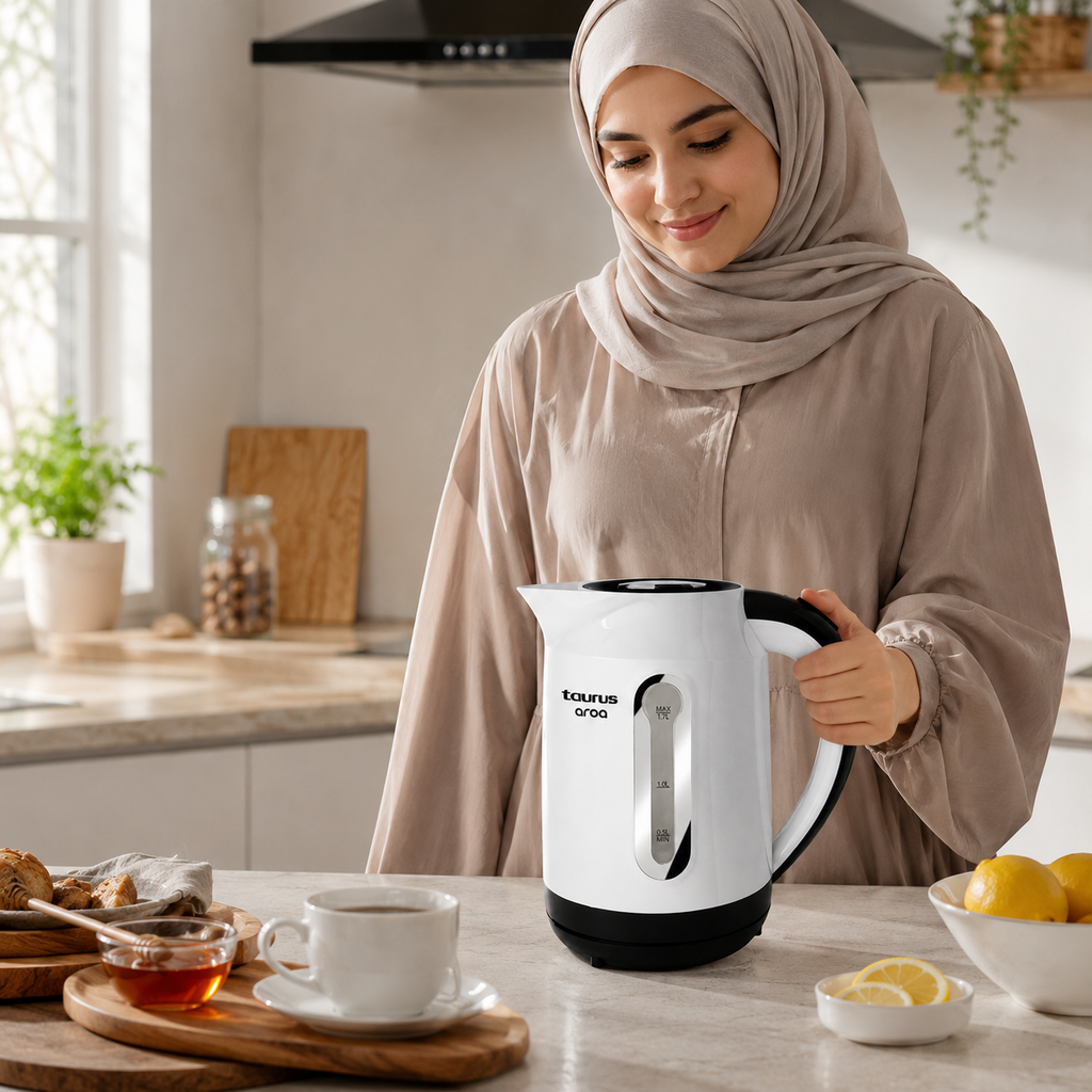Femme en hijab beige tenant la bouilloire Taurus Aroa dans une cuisine lumineuse avec thé et citrons
