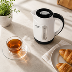 Bouilloire Taurus Aroa vue de dessus sur plan de travail lumineux avec tasse de thé et croissants